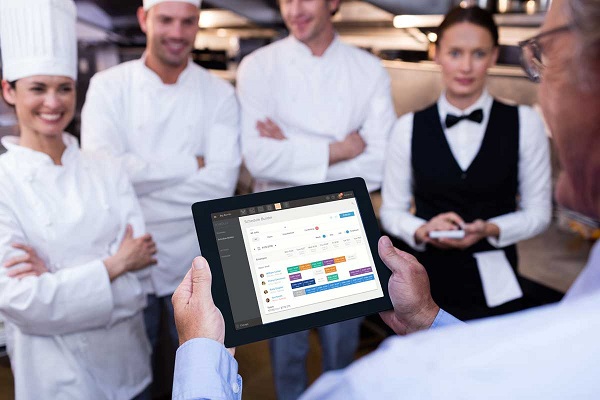 The image represents managing restaurant staff using restaurant management software.